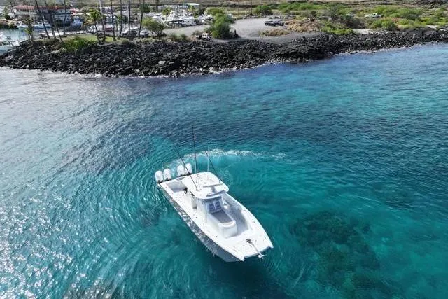  Yacht Photos Pics Aerial view of 2022 Freeman 37 VH boat on clear turquoise water near rocky shoreline.