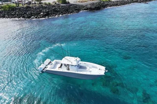  Yacht Photos Pics Aerial view of 2022 Freeman 37 VH boat on clear turquoise water near rocky shore.