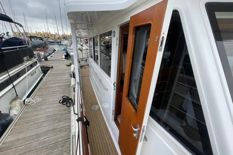 Peponi II Yacht Photos Pics 2008 Grand Banks 47 Heritage EU yacht docked at marina, showcasing side deck and wooden door.