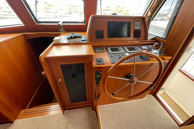 Peponi II Yacht Photos Pics 2008 Grand Banks 47 Heritage EU helm with wooden steering wheel and navigation controls.