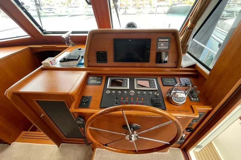 Peponi II Yacht Photos Pics Helm station of 2008 Grand Banks 47 Heritage EU yacht with navigation controls and wooden steering wheel.