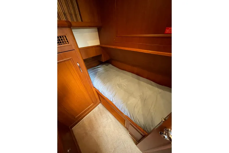 Peponi II Yacht Photos Pics Cozy cabin bed in 2008 Grand Banks 47 Heritage EU yacht, featuring elegant wood paneling.