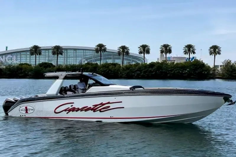  Yacht Photos Pics 2024 Cigarette 42 Auroris boat on water, modern design, palm trees in background.