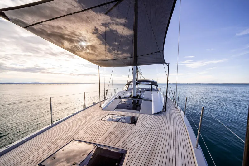  Yacht Photos Pics 2023 Jeanneau 65 Yacht sailing on calm waters under a clear sky.