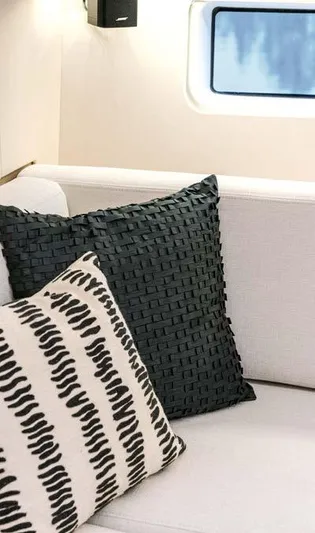  Yacht Photos Pics Interior of 2023 Jeanneau 65 Yacht with stylish cushions on a sofa.