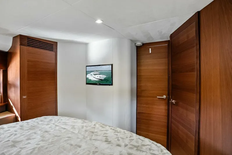 Zefa Yacht Photos Pics Interior of 2019 Princess 43 Flybridge yacht bedroom with wooden doors and wall-mounted TV.