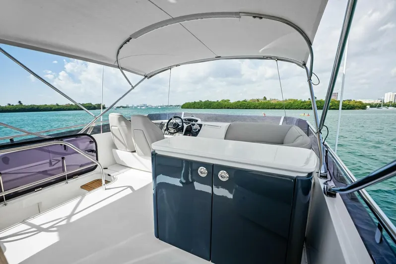Zefa Yacht Photos Pics 2019 Princess 43 Flybridge yacht interior with seating and helm, overlooking serene waters.