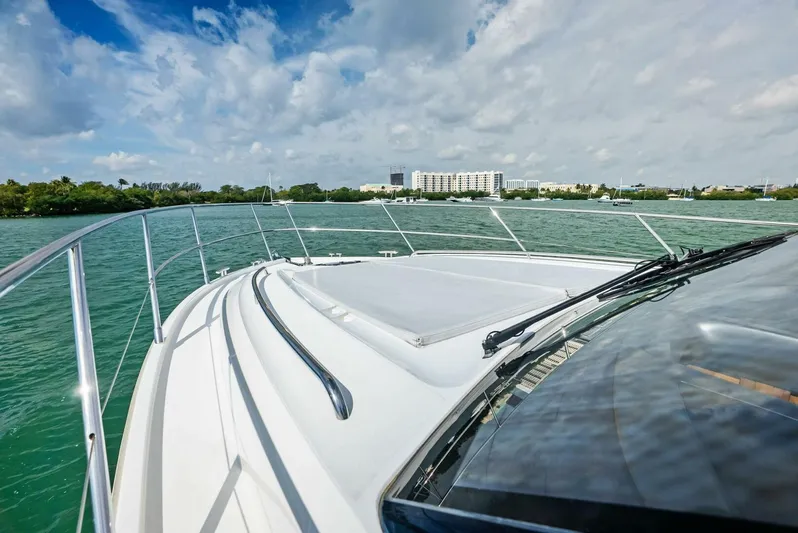 Zefa Yacht Photos Pics 2019 Princess 43 Flybridge yacht cruising on a scenic waterway under a partly cloudy sky.