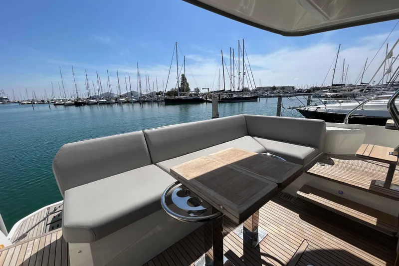 Yacht Photos Pics Luxurious 2023 Prestige 520 yacht deck with seating, overlooking a marina filled with sailboats.
