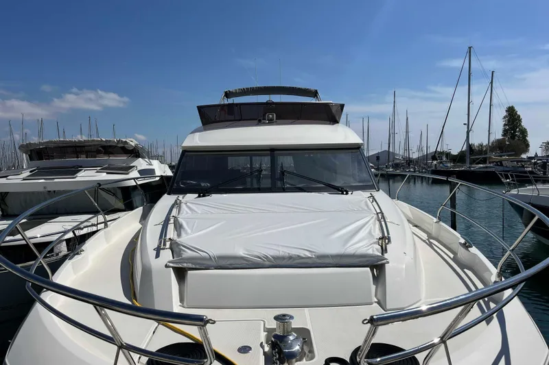  Yacht Photos Pics 2023 Prestige 520 yacht docked in a marina under a clear blue sky.