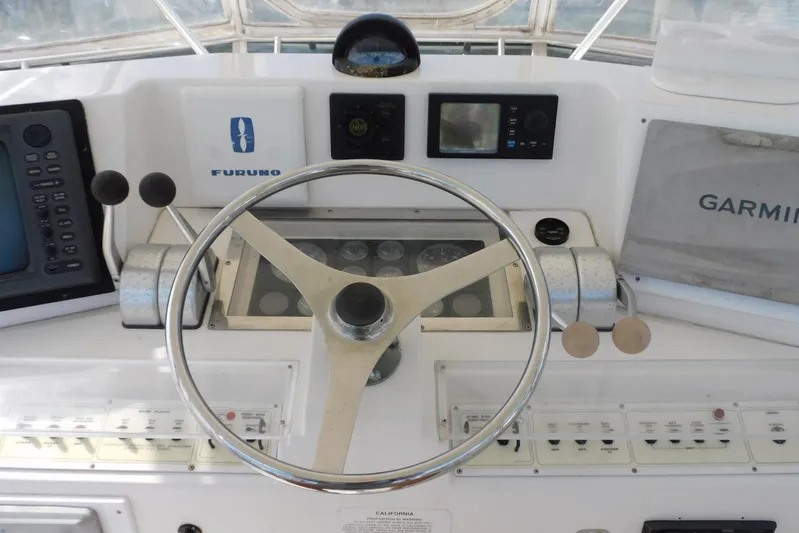 Mishap Yacht Photos Pics 1999 Cabo 35 Flybridge Sportfisher helm with steering wheel and navigation equipment.