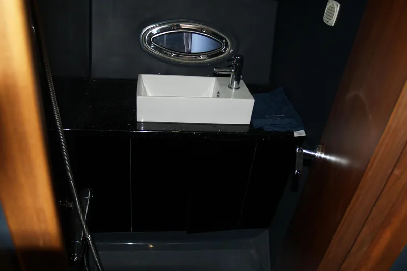 Speedbird Yacht Photos Pics Interior of 2012 Hunton XRS 43 yacht bathroom with modern sink and porthole window.