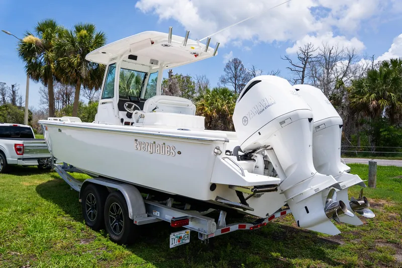  Yacht Photos Pics 2021 Everglades 273 Center Console boat on trailer, twin Yamaha engines, parked on grass.
