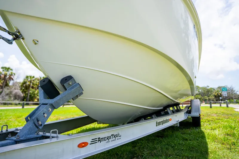  Yacht Photos Pics 2021 Everglades 273 Center Console boat on trailer, parked on grassy area.