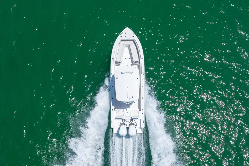 Yacht Photos Pics Aerial view of 2021 Everglades 273 Center Console boat cruising on green water.