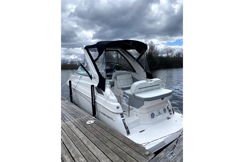  Yacht Photos Pics 2023 Regal 28 Express boat docked on a lake under cloudy skies.