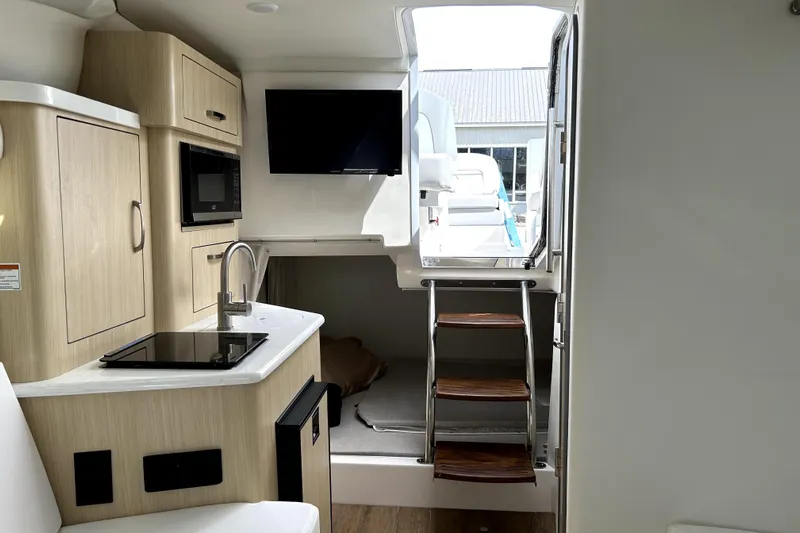  Yacht Photos Pics Interior of 2023 Regal 28 Express boat with kitchenette and stairs to deck.