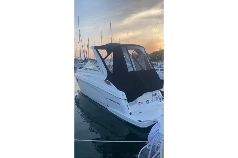  Yacht Photos Pics 2023 Regal 28 Express boat docked at sunset with black canopy.
