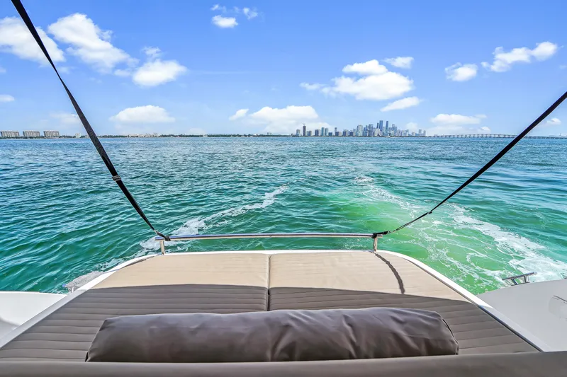 Above & Beyond Yacht Photos Pics Azimut 43 ATLANTIS 2016 yacht with city skyline view over turquoise waters.