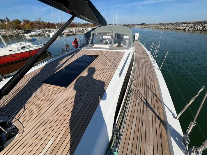 Xaca Yacht Photos Pics Xp 55 yacht deck with wooden finish, docked in a marina, sunny day.