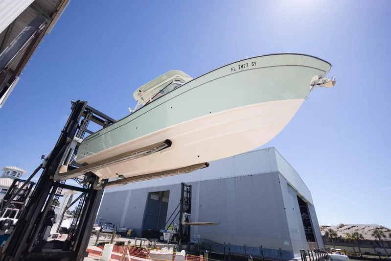  Yacht Photos Pics 2021 Grady-White Freedom 275 boat lifted by forklift near large warehouse.