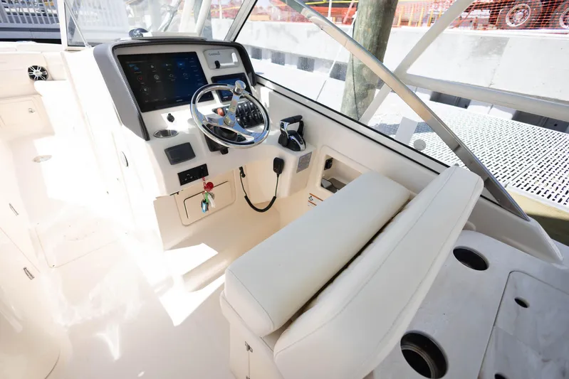  Yacht Photos Pics 2021 Grady-White Freedom 275 boat cockpit with steering wheel and control panel.