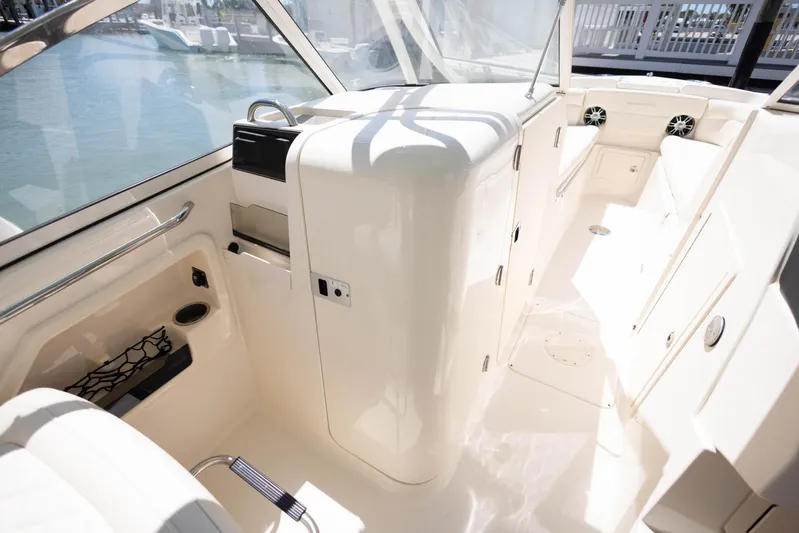  Yacht Photos Pics 2021 Grady-White Freedom 275 boat interior with seating and storage, docked by the water.