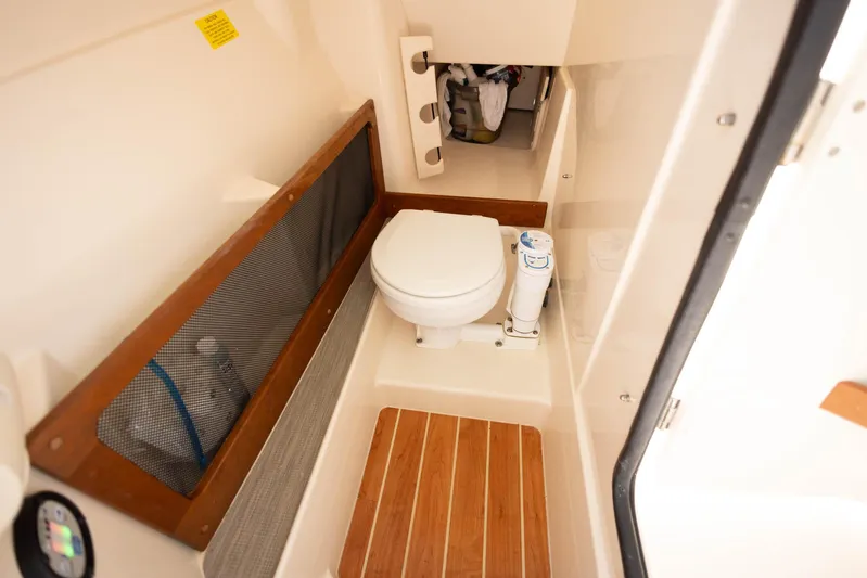  Yacht Photos Pics 2021 Grady-White Freedom 275 boat interior with compact marine toilet.