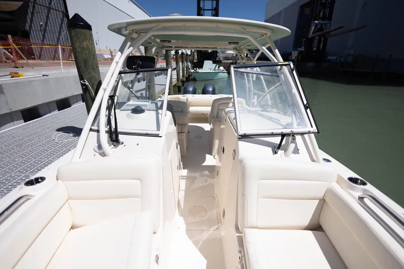  Yacht Photos Pics 2021 Grady-White Freedom 275 boat interior with seating and open windshield at dock.