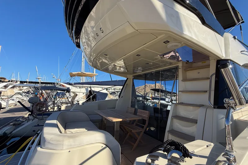  Yacht Photos Pics 2018 Beneteau Monte Carlo 5 yacht with outdoor seating, docked at marina.