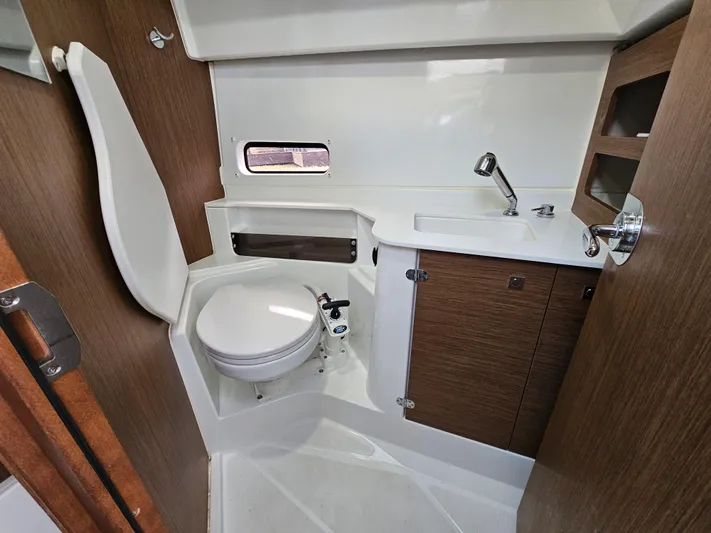  Yacht Photos Pics 2020 Beneteau Antares 9 bathroom with toilet, sink, and wooden cabinetry.