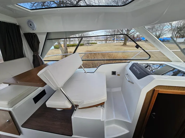  Yacht Photos Pics Interior of 2020 Beneteau Antares 9 boat with seating and table, showcasing modern design.