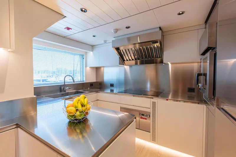Ducale 120 Yacht Photos Pics Modern yacht kitchen with stainless steel appliances, fruit bowl, and sleek design. Ocean King Ducale 120, 2027.