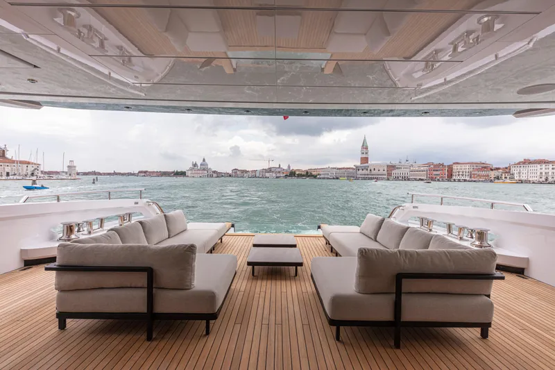 Ducale 120 Yacht Photos Pics Luxurious Ocean King Ducale 120 yacht deck with elegant seating, overlooking a scenic waterfront view.