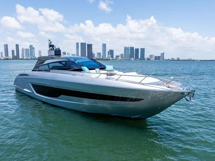 Club T Yacht Photos Pics 2023 Riva 68 Diable yacht cruising near city skyline on a sunny day.