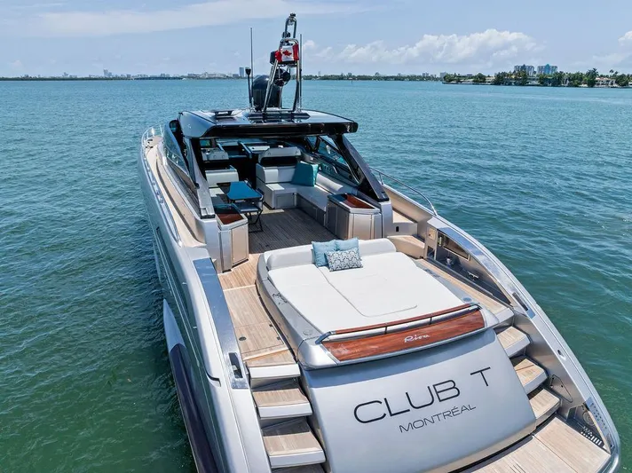 Club T Yacht Photos Pics Luxurious 2023 Riva 68 Diable yacht on serene water, featuring spacious deck and elegant design.