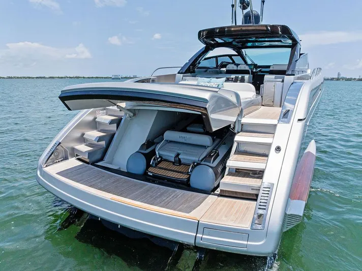 Club T Yacht Photos Pics 2023 Riva 68 Diable luxury yacht with open garage on calm water.