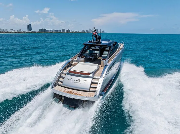 Club T Yacht Photos Pics 2023 Riva 68 Diable luxury yacht cruising on open sea with city skyline in background.