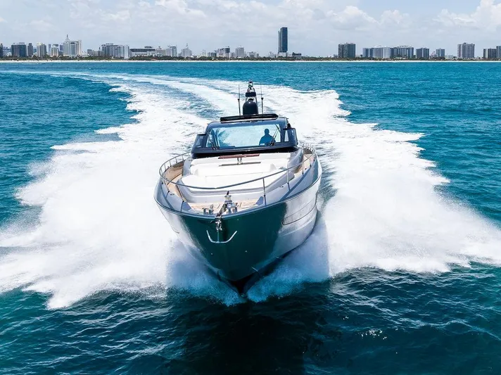 Club T Yacht Photos Pics 2023 Riva 68 Diable yacht cruising on blue ocean near city skyline.