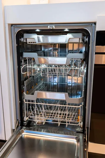 Club T Yacht Photos Pics Open dishwasher with multiple racks inside a modern kitchen setting.