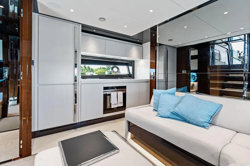 Club T Yacht Photos Pics Luxurious interior of 2023 Riva 68 Diable yacht with modern kitchen and seating area.