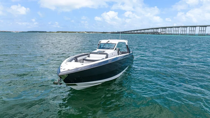  Yacht Photos Pics 2022 Cigarette 42 Auroris boat on open water near a bridge under blue skies.