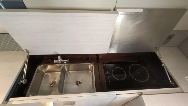  Yacht Photos Pics Compact kitchen area in a 1998 Otam 55 Millenium yacht with dual sinks and stovetop.
