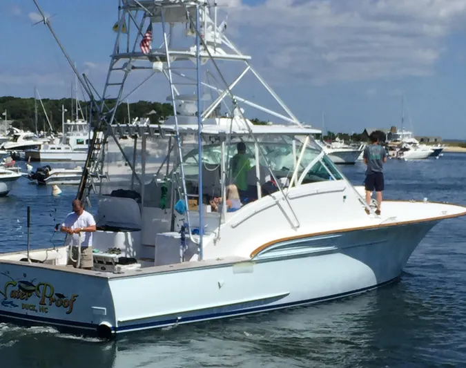 Waterproof Yacht Photos Pics 2001 Davis 45 Express boat on water, people onboard, marina background.