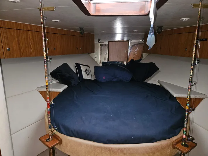 Waterproof Yacht Photos Pics Interior cabin of 2001 Davis 45 Express boat with cozy bedding and fishing rods.