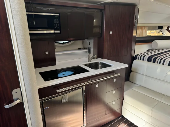 Kaja Yacht Photos Pics 2018 Monterey 335 SY yacht interior with kitchenette, featuring sink, stove, microwave, and seating area.