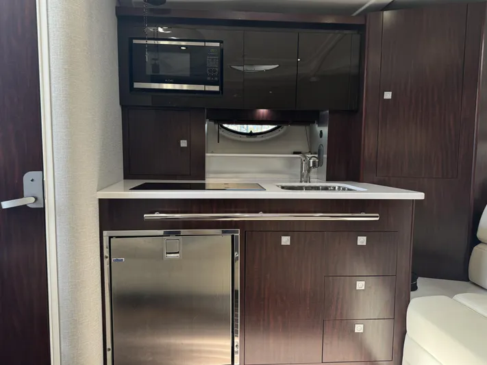 Kaja Yacht Photos Pics 2018 Monterey 335 SY yacht kitchen with microwave, sink, and dark wood cabinetry.