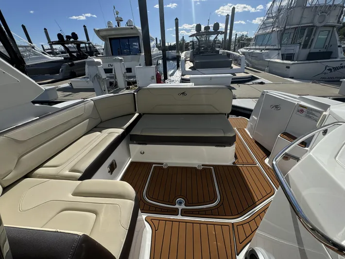 Kaja Yacht Photos Pics 2018 Monterey 335 SY boat interior with cushioned seating and wooden deck at marina.