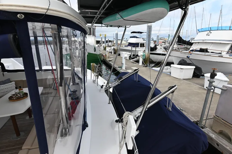 Yacht Photos Pics 2009 Lagoon 440 catamaran docked at marina, featuring covered seating and paddleboard storage.