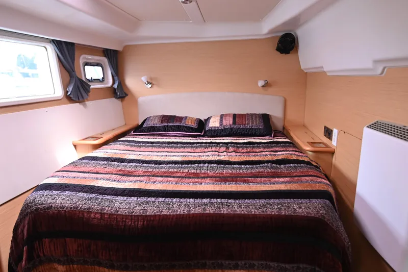  Yacht Photos Pics Luxurious bedroom interior of 2009 Lagoon 440 yacht with striped bedding and modern design.
